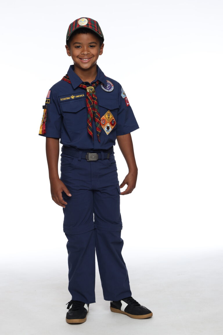 A Cub Scout in full uniform with plaid neckerchief and rank badges