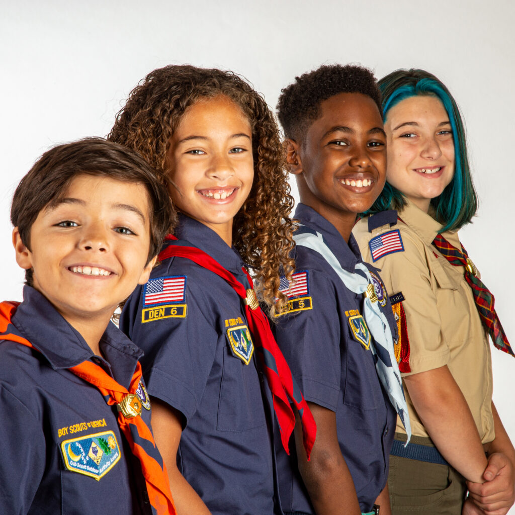Four Cub Scouts in uniform smiling together